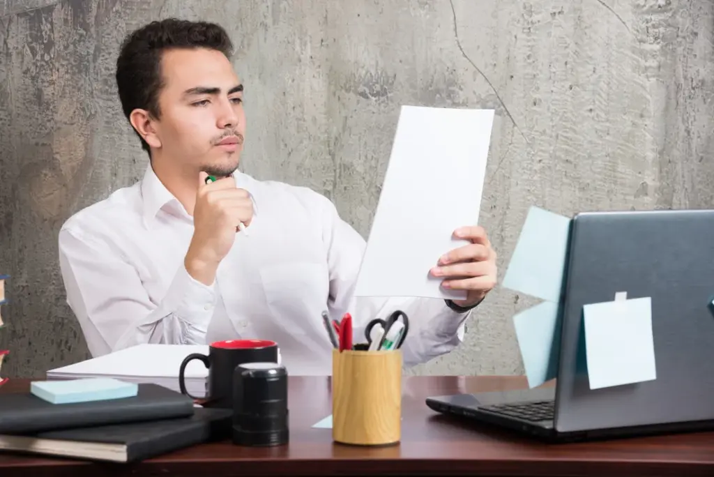 young-businessman-looking-work-papers-office-desk